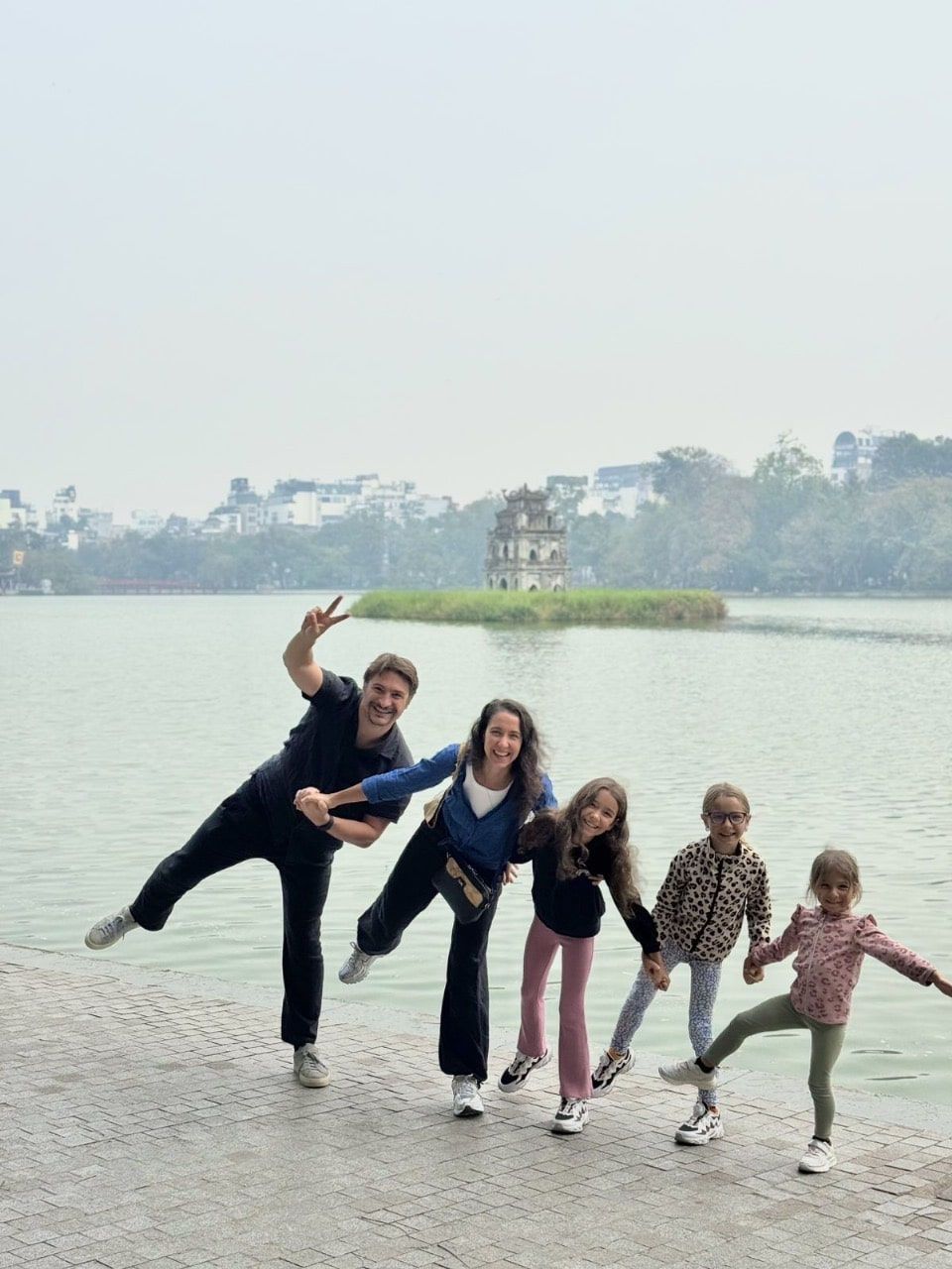 A family on a Vespa tour at Hoan Kiem lake