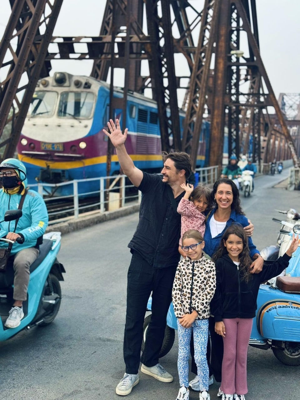 A family on a Vespa tour at Hanoi Long Bien bridge